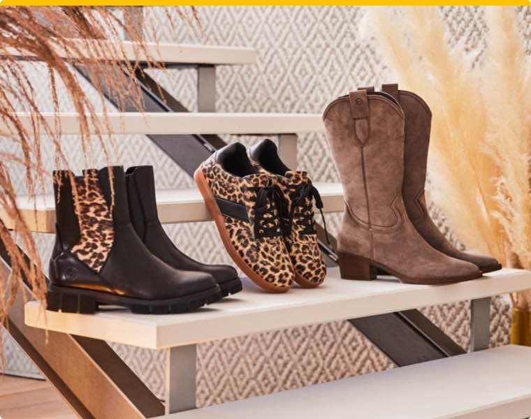 Verschiedene Schuhmodelle mit Leo-Muster und in Erdtönen stehen auf einer Treppe