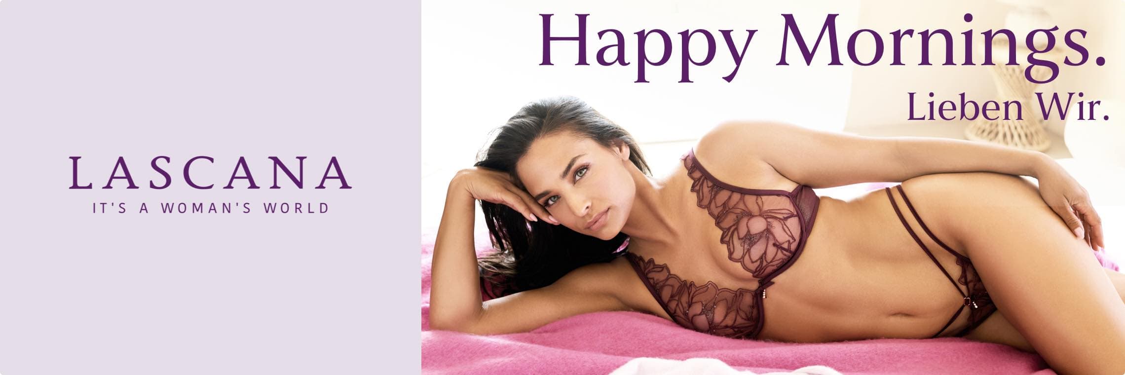 Happy Mornings. Lieben Wir. Lascana – Frau in bordeauxfarbenem Spitzen-BH und Slip liegt auf rosa Bettdecke