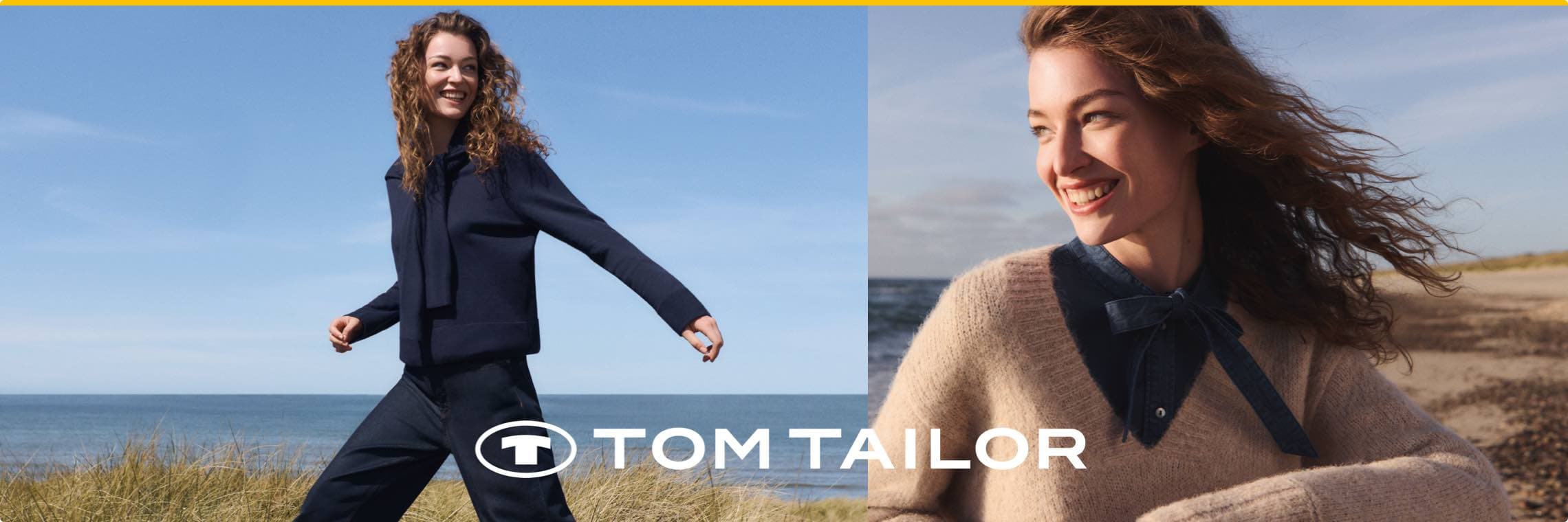 Tom Tailor – Frau in dunkler Jacke spaziert am Strand, andere Frau trägt beigen Pullover mit blauem Kragen am Meer.