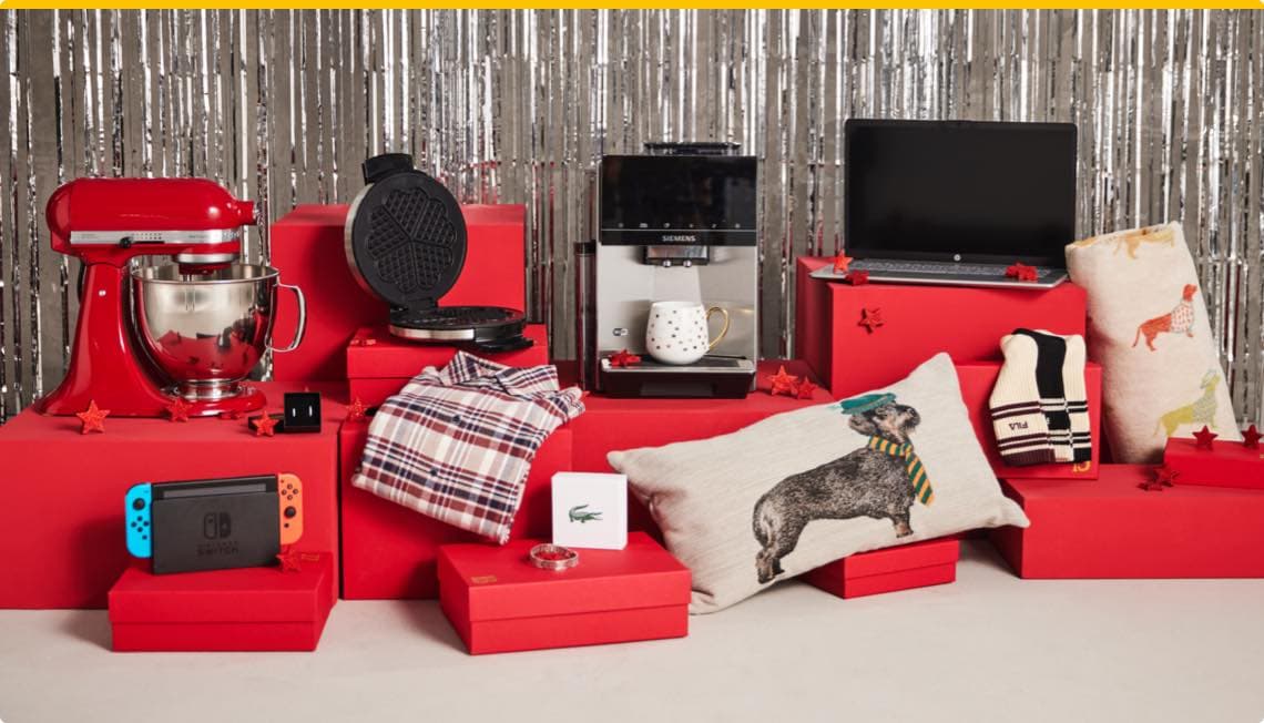 Geschenke auf roten Boxen – Küchenmaschine, Waffeleisen, Kaffeemaschine, Laptop, Nintendo Switch, Kissen, Schal, Hemd und Lacoste-Box