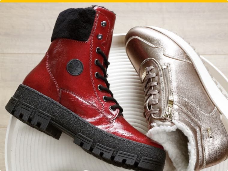 Roter glänzender Schnürstiefel mit schwarzem Kragen neben einem goldenen Sneaker mit Reißverschluss und weißem Innenfutter