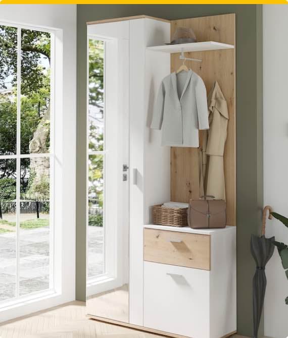 Garderobe mit Spiegel, Haken für Jacken, Hutablage, Körbchen und Schubladen, daneben Fenster mit Blick ins Grüne