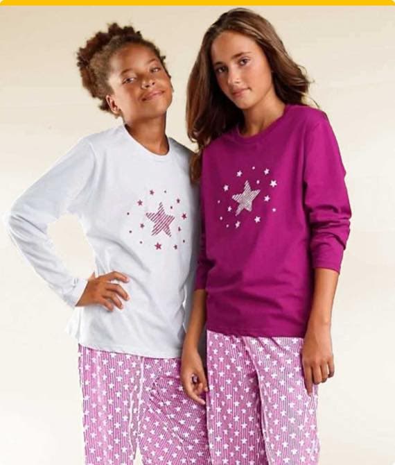 Zwei Mädchen in Pyjamas, weißes und pinkes Oberteil mit Sternenmuster, beide tragen passende rosa Hosen mit Sternenprints.