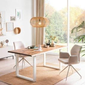 Modernes Esszimmer mit Holztisch, zwei beigen Stühlen und Lampe aus Holz, große Fenster mit Blick ins Grüne.