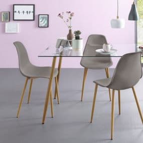 Essbereich mit Glas-Tisch und vier grauen Stühlen vor rosa Wand mit gerahmten Bildern