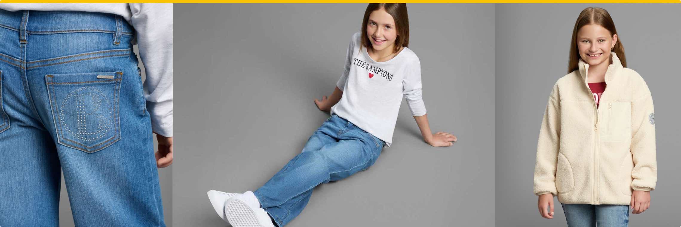 Kind in "The Hamptons"-Shirt und Jeans sitzt auf Boden, Detailansicht von Jeans-Tasche mit glitzerndem B-Logo, Kind in heller Fleecejacke