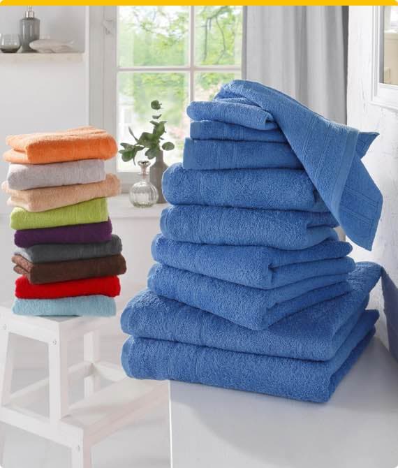 Gestapelte bunte Handtücher, im Vordergrund blaue Handtücher und im Hintergrund ein Stapel in verschiedenen Farben