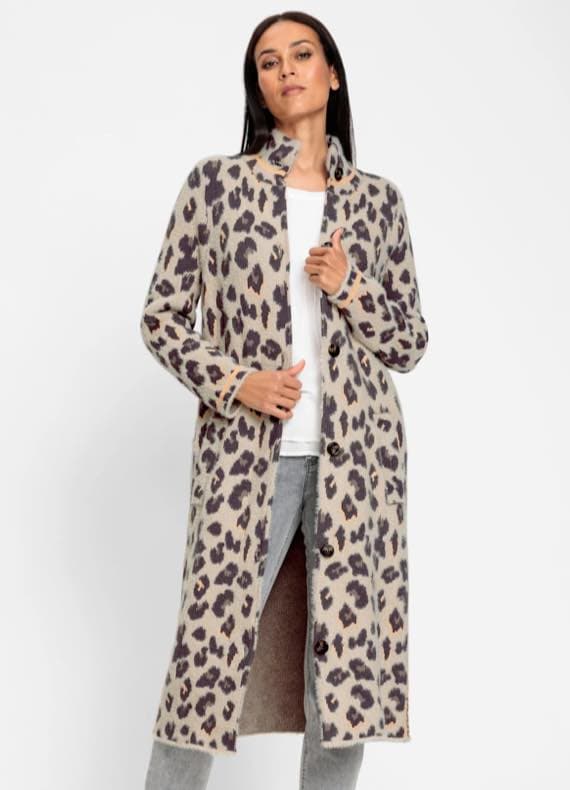 Frau trägt langen Cardigan mit Leopardenmuster, weißes Shirt und graue Jeans.