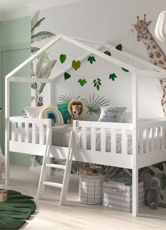 Hochbett in Kinderzimmer mit Blättergirlande, Löwenkuscheltier und Regenbogenkissen. Wand mit Blätter- und Giraffenmotiv.
