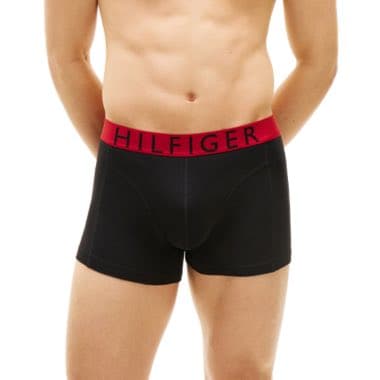 Person trägt schwarze Boxershorts mit rotem Bund und dem Schriftzug "Hilfiger"