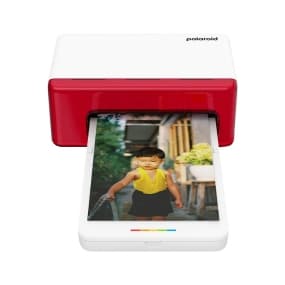Polaroid-Drucker druckt Foto eines Kindes in gelbem Oberteil und schwarzer Hose