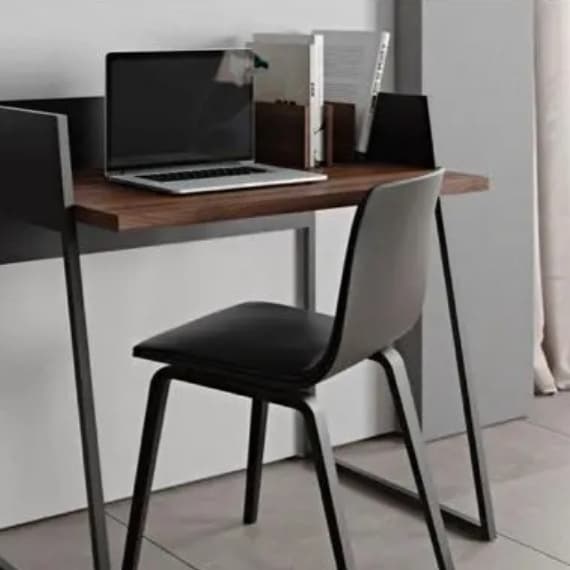 Schreibtisch mit Laptop, Büchern und Stuhl in modernem Raum mit Vorhängen.