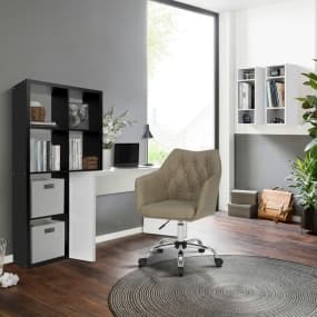 Modernes Home-Office mit grauem Drehstuhl, weißem Schreibtisch und schwarzem Regal vor einem großen Fenster.