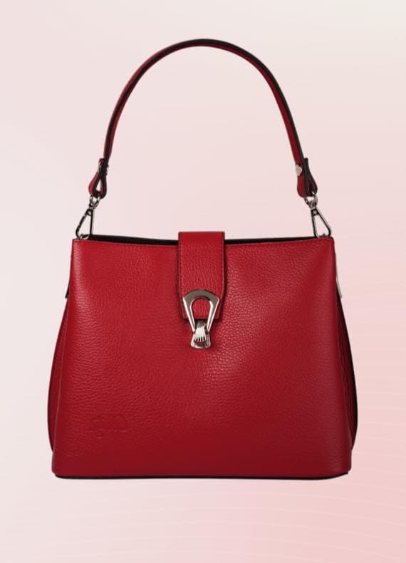 Rote Handtasche mit silbernem Verschluss und einem Henkel vor rosa Hintergrund