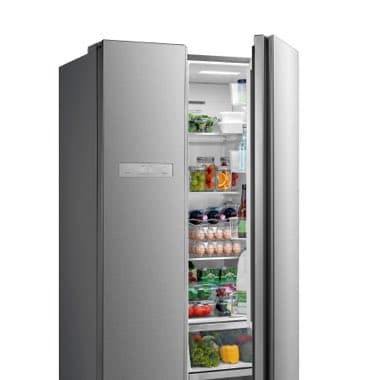 Geöffneter silberner Kühlschrank mit verschiedenen Lebensmitteln wie Gemüse, Eier und Getränke.