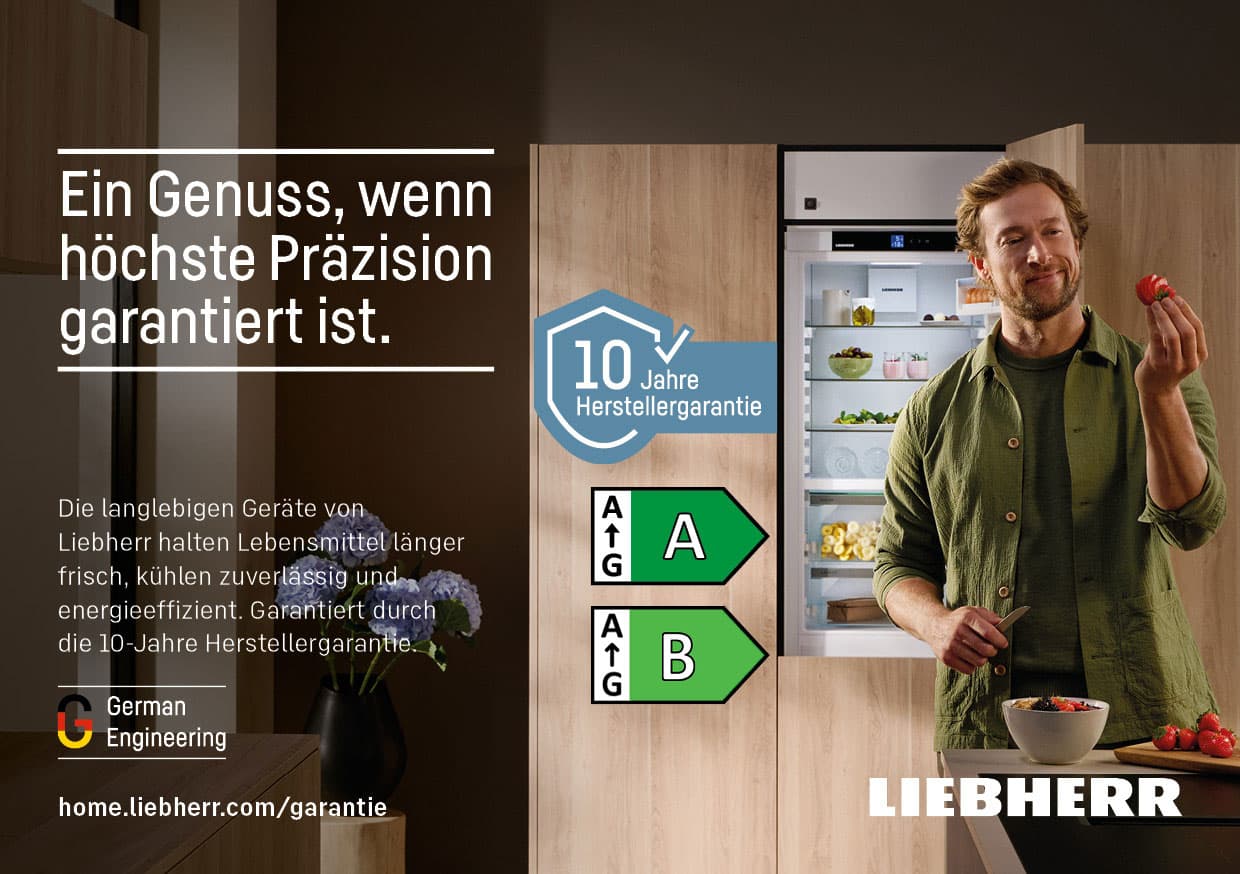Ein Genuss, wenn höchste Präzision garantiert ist. Mann neben offenem Kühlschrank mit Erdbeere und Schüssel. 10 Jahre Herstellergarantie.