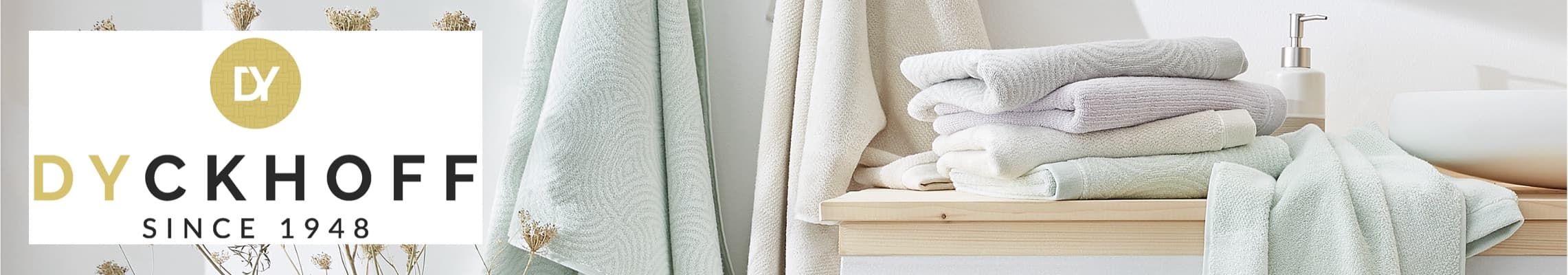 Dyckhoff Since 1948 – Gestapelte Handtücher und Seifenspender auf Holzregal in Badezimmer.