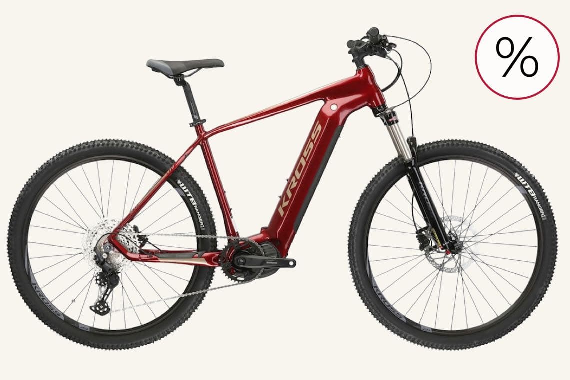 Prozentzeichen für Rabatt – rotes E-Bike im Profil mit dicken Reifen vor hellem Hintergrund