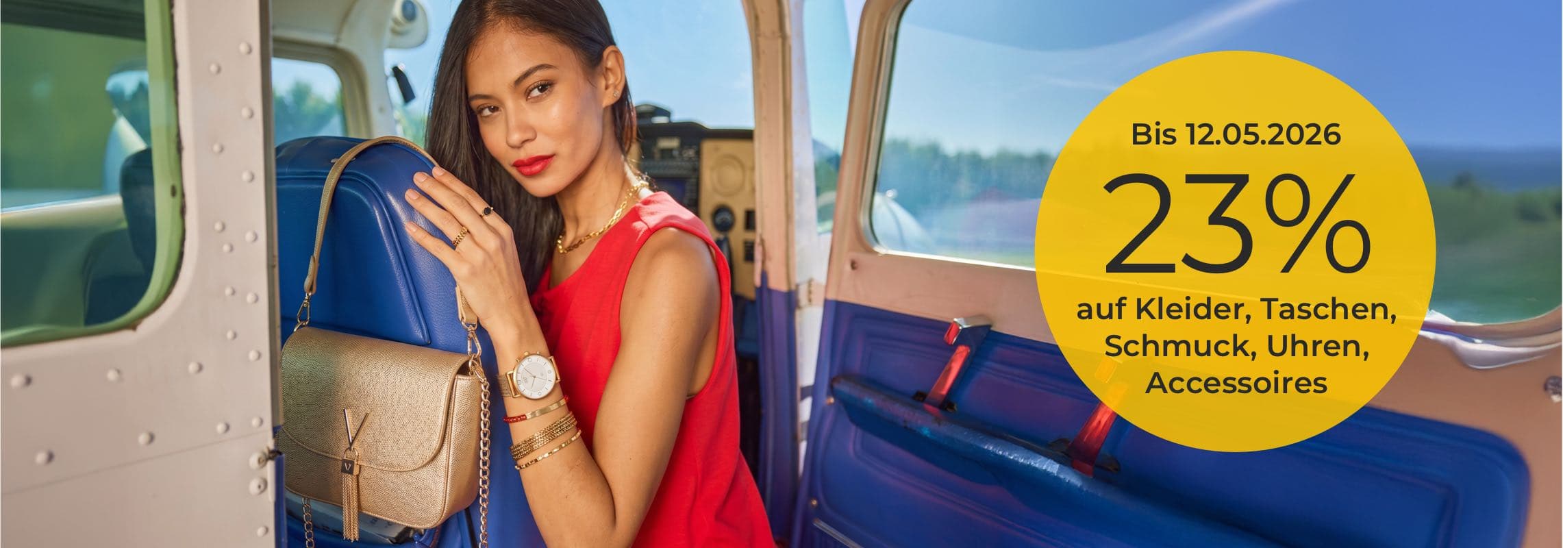 Bis 12.05.2026 23 % auf Kleider, Taschen, Schmuck, Uhren, Accessoires – Person im Flugzeug hält blaue Tasche mit Umhängetasche
