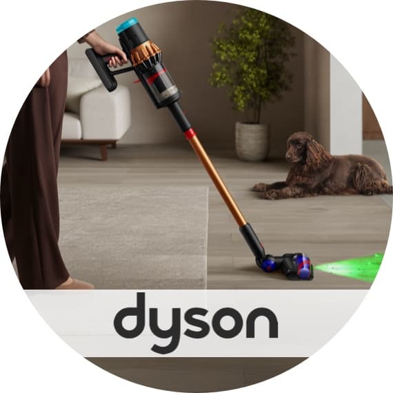 Dyson – Person saugt Wohnzimmerboden mit kabellosem Staubsauger, Hund liegt daneben auf dem Boden