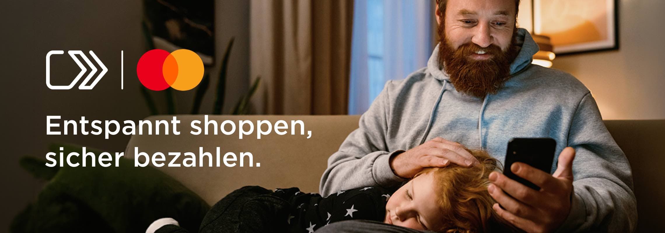 Entspannt shoppen, sicher bezahlen – Mann auf Sofa schaut aufs Smartphone, Kind liegt mit Kopf auf seinem Schoß