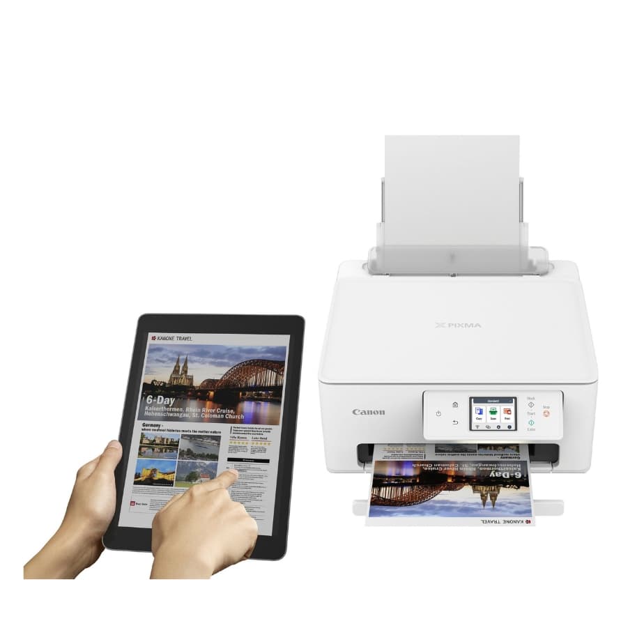 Tablet mit Reiseprospekt wird von Händen bedient, daneben weißer Drucker, der das farbige Prospekt ausgibt