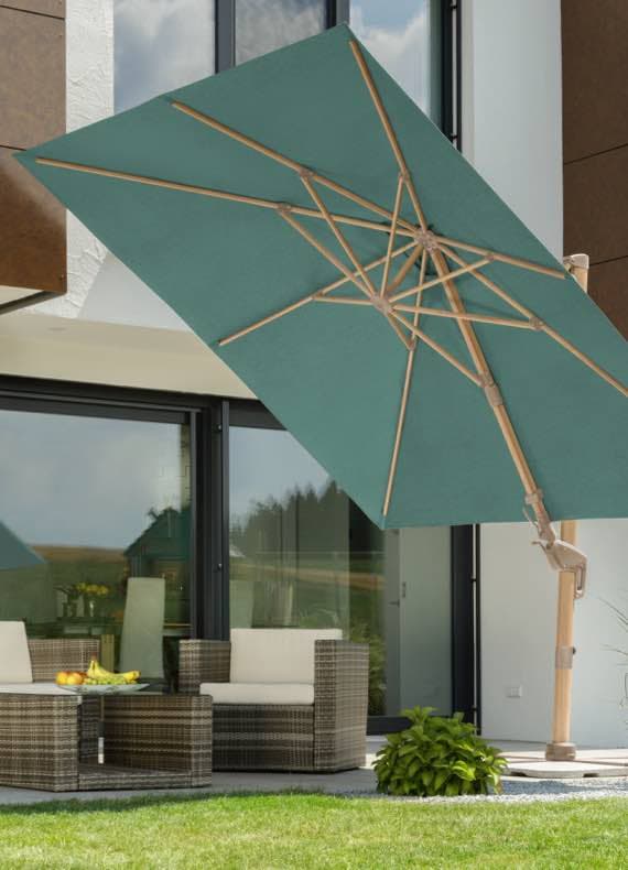 Großer eckiger Sonnenschirm über Sitzgruppe auf Terrasse vor modernem Haus