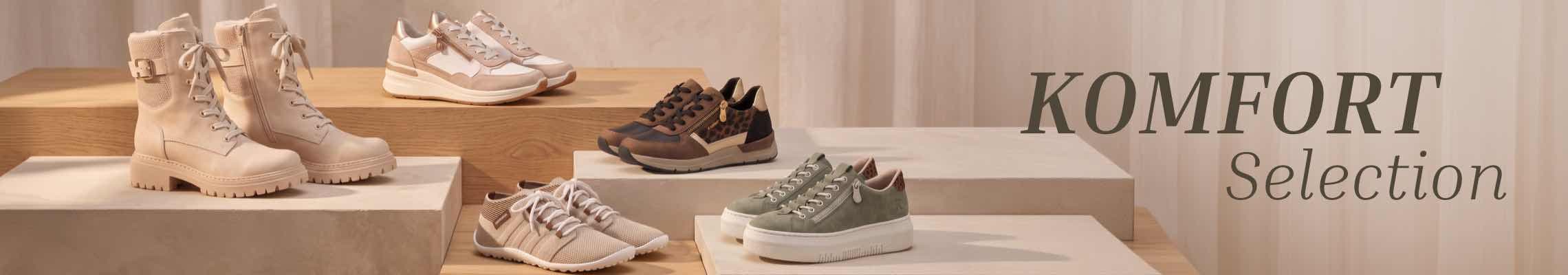 KOMFORT Selection – mehrere Paar Schnürschuhe und Stiefel in Naturtönen auf gestuften Podesten ausgestellt
