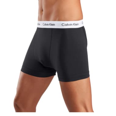 Schwarze Herren-Boxershorts mit weißem Bund und Calvin-Klein-Schriftzug, getragen von einem stehenden Mann