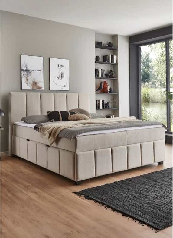 Doppelbett mit hohem Kopfteil in modernem Schlafzimmer, Regal mit Deko und großes Fenster mit Blick ins Grüne