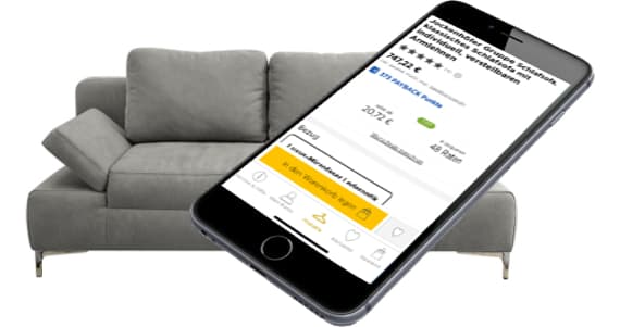 Smartphone zeigt Möbelangebot – graues Sofa mit zwei Kissen und Armlehne links im Hintergrund