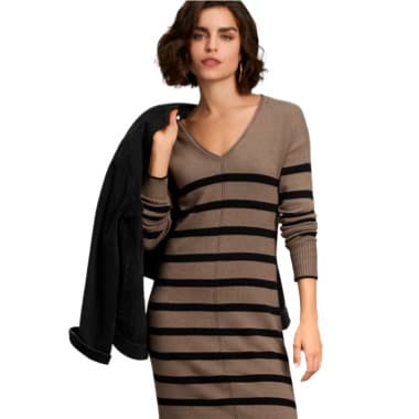 Frau trägt braun-schwarz gestreiftes Kleid und hält schwarze Jacke über Schulter