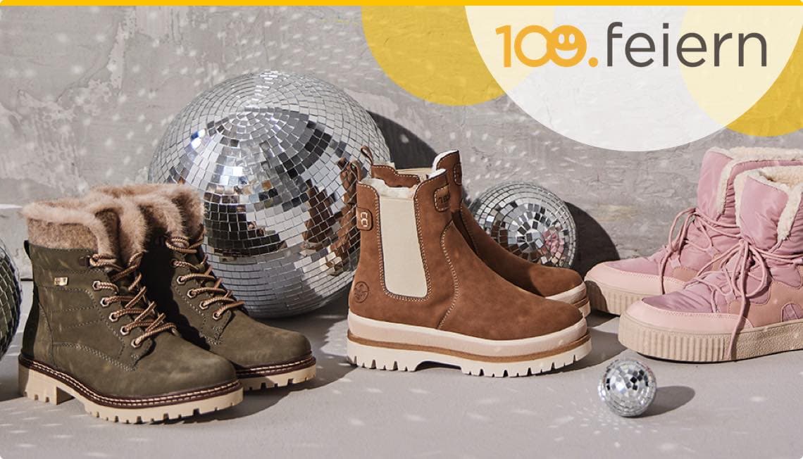 100. feiern – Drei Paar Winterstiefel in verschiedenen Farben vor zwei silbernen Diskokugeln