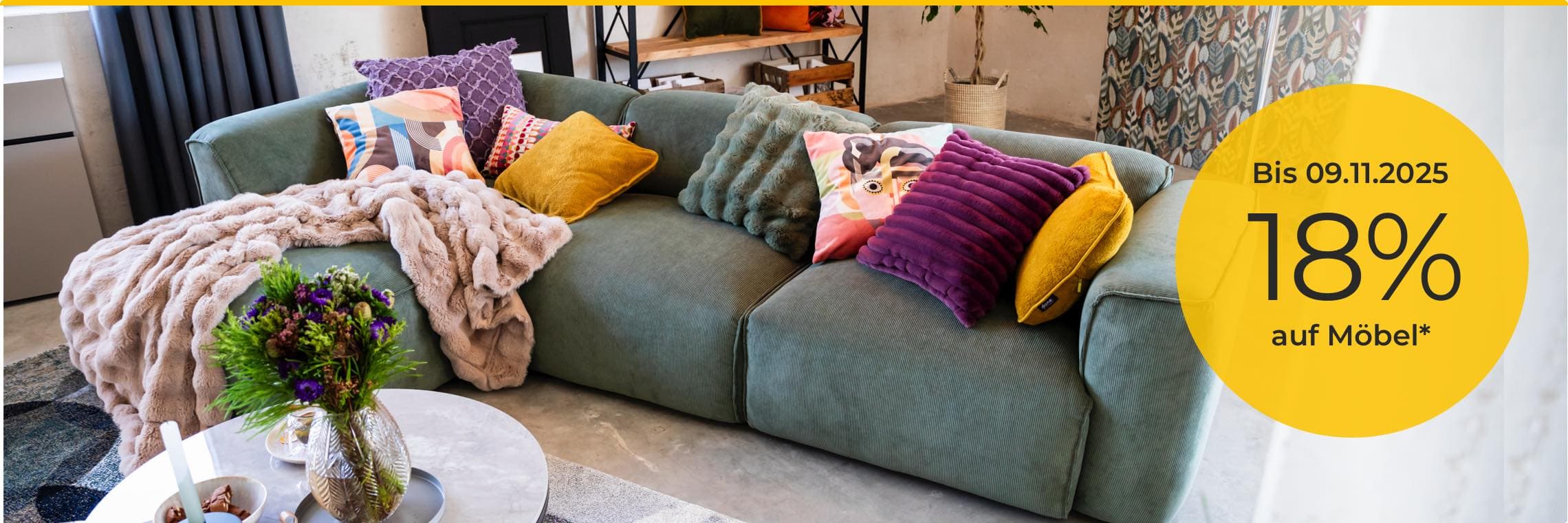 18% auf Möbel bis 09.11.2025, Ecksofa mit bunten Kissen und Decke in einem gemütlich dekorierten Wohnzimmer