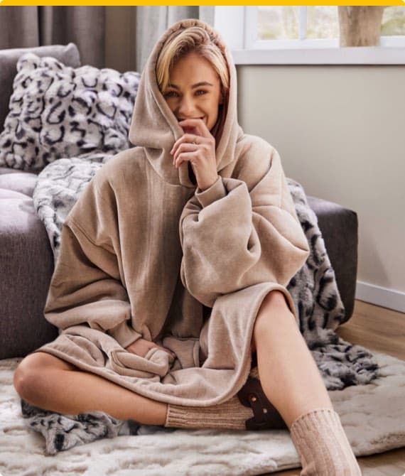 Dunkler Schrank mit dekorativen Vasen und Skulpturen in beleuchtetem Regal. Gelbe und blaue Vasen oben, Pampasgras daneben.