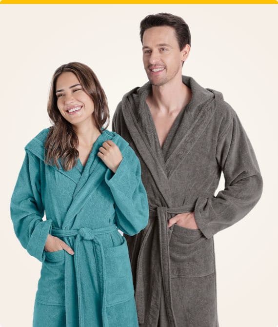 Zwei Personen tragen Bademäntel, eine in Türkis und die andere in Grau, beide mit Taschen und Bindegürtel.