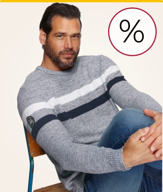 Prozentzeichen – Mann in grau-weiß gestreiftem Pullover sitzt auf einem Stuhl