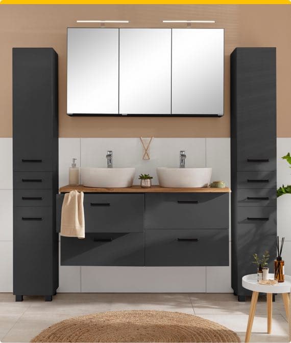 Doppelwaschtisch mit zwei schwarzen Schränken und Spiegel, Handtuch hängt am Waschtisch, Pflanze und Deko auf Boden