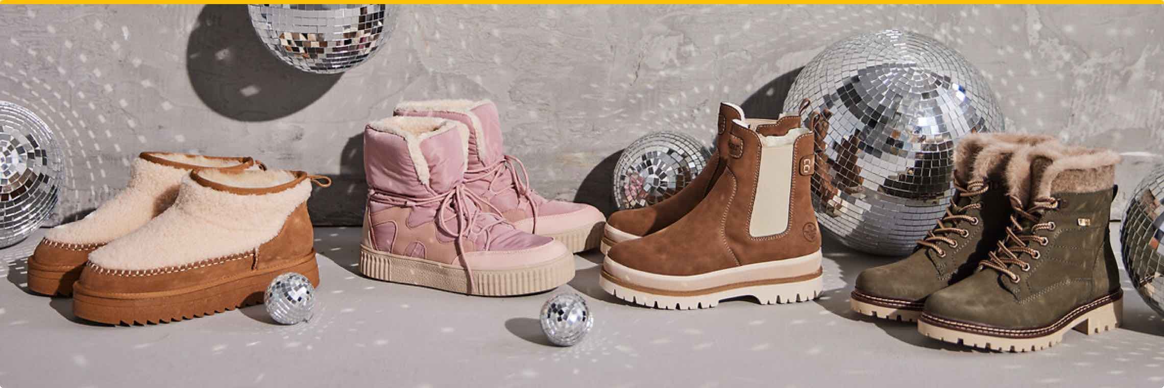 Vier Paar Winterstiefel in verschiedenen Farben vor grauer Wand, umgeben von glänzenden Disco-Kugeln.