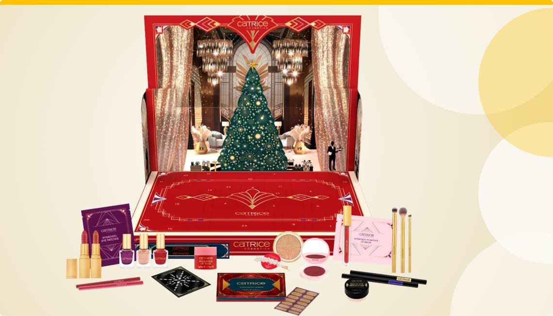 Catrice Adventskalender – festlich dekorierter Weihnachtsbaum und verschiedene Kosmetikprodukte wie Lippenstift, Pinsel und Nagellack