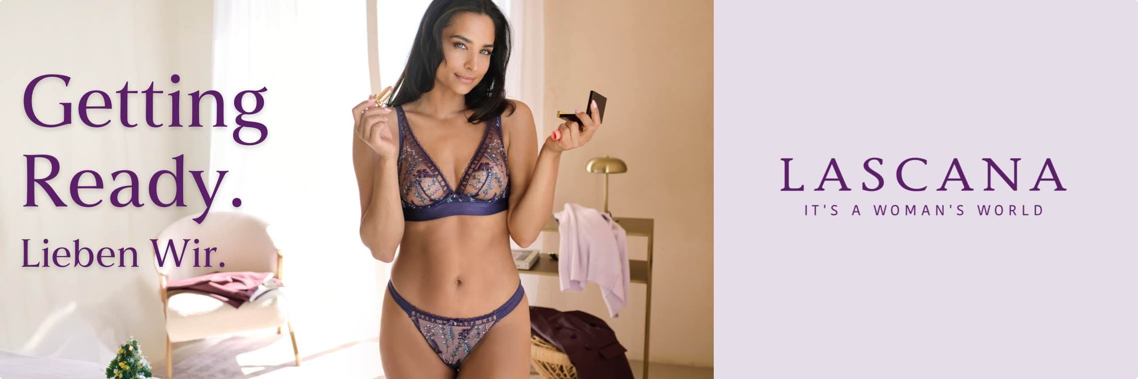 Getting Ready. Lieben Wir. LASCANA – Frau in blauem Spitzen-BH und Slip trägt Lippenstift auf