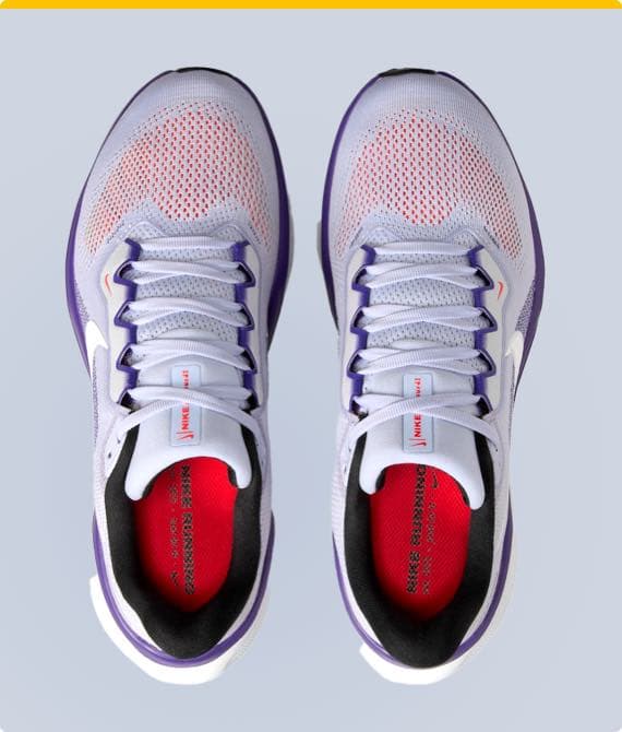 Obenansicht von weißen Nike-Laufschuhen mit lila Akzenten und roten Einlegesohlen.