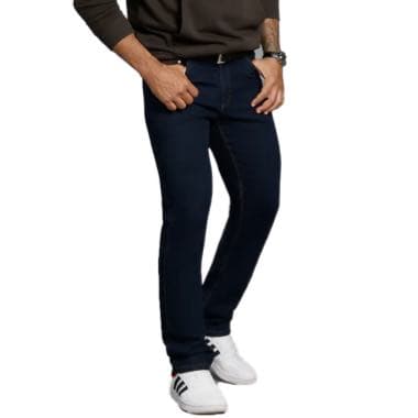 Mann in dunkelblauer Jeans und weißen Sneakers steht mit Händen in den Hosentaschen und trägt ein langärmliges Oberteil