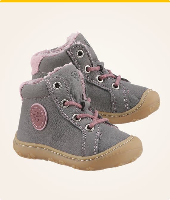 Graue Kinderstiefel mit rosa Schnürsenkeln und rosa Details auf beigem Hintergrund