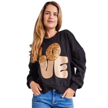 Schwarzer Pullover mit goldenen Pailletten und dem Schriftzug "LOVE", Frau trägt Jeans und hat lange Haare.